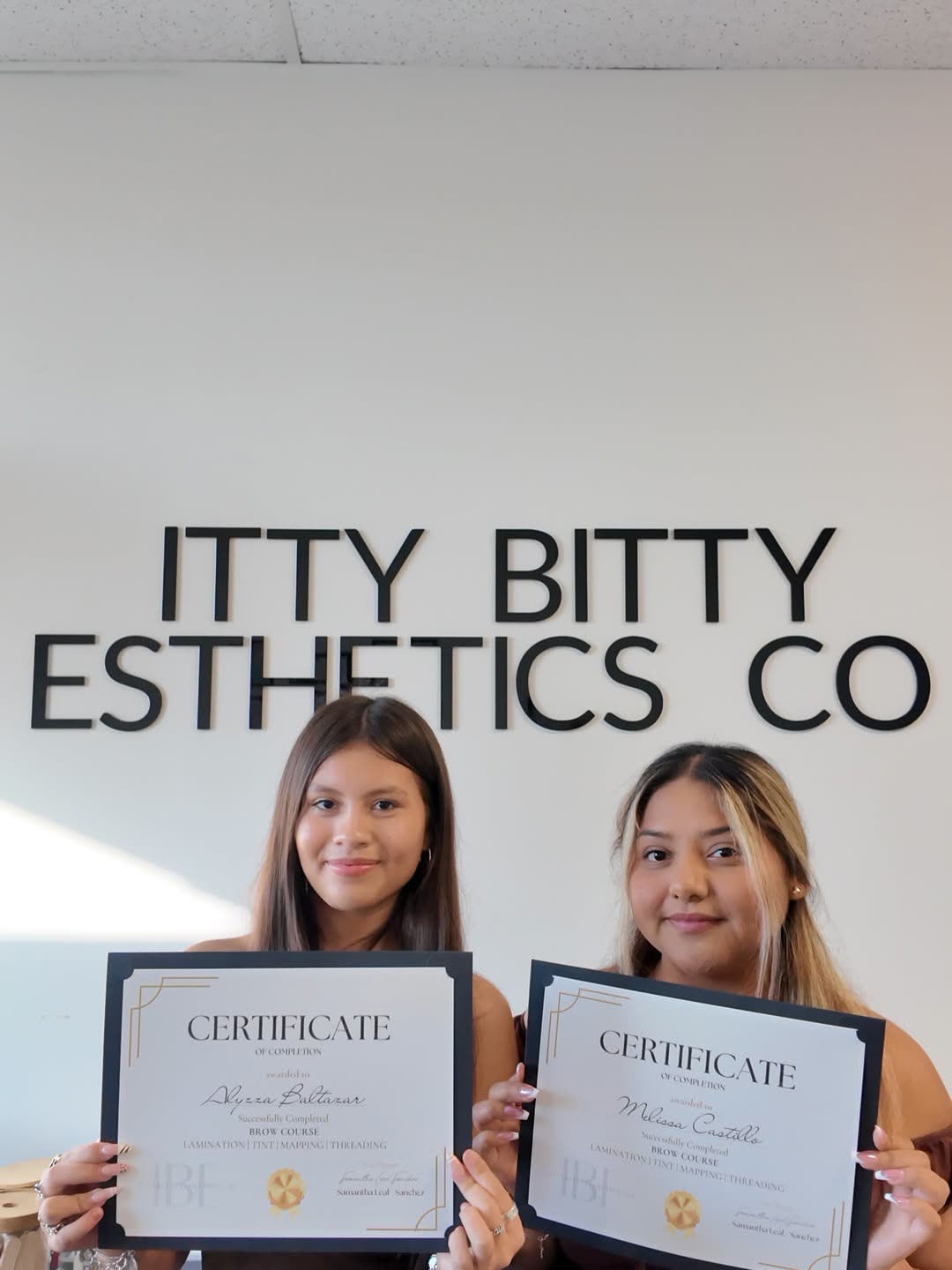 Two graduates with certificates