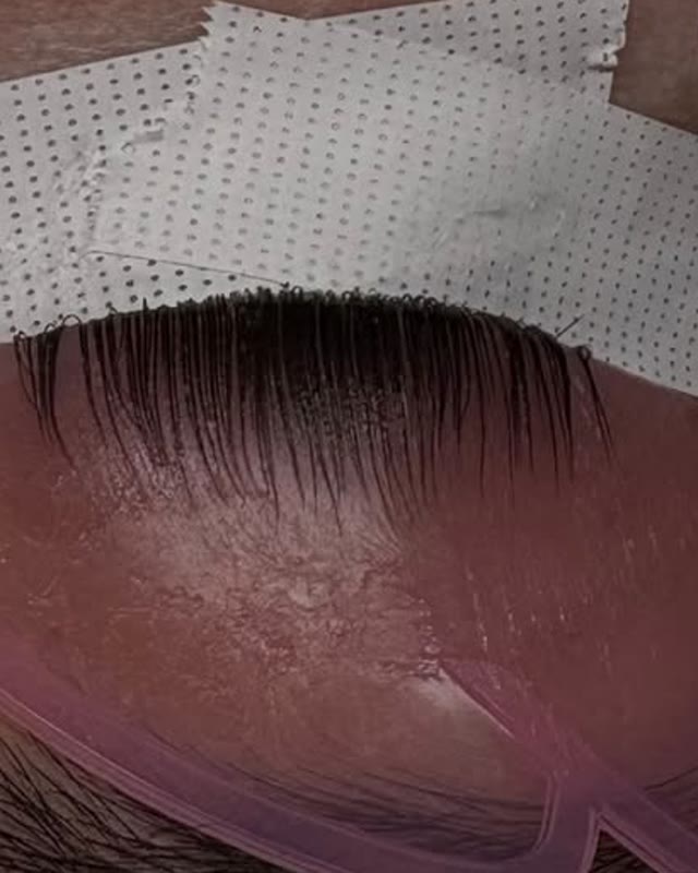 Natural lashes set on a pink lift pad during a Korean lash lift