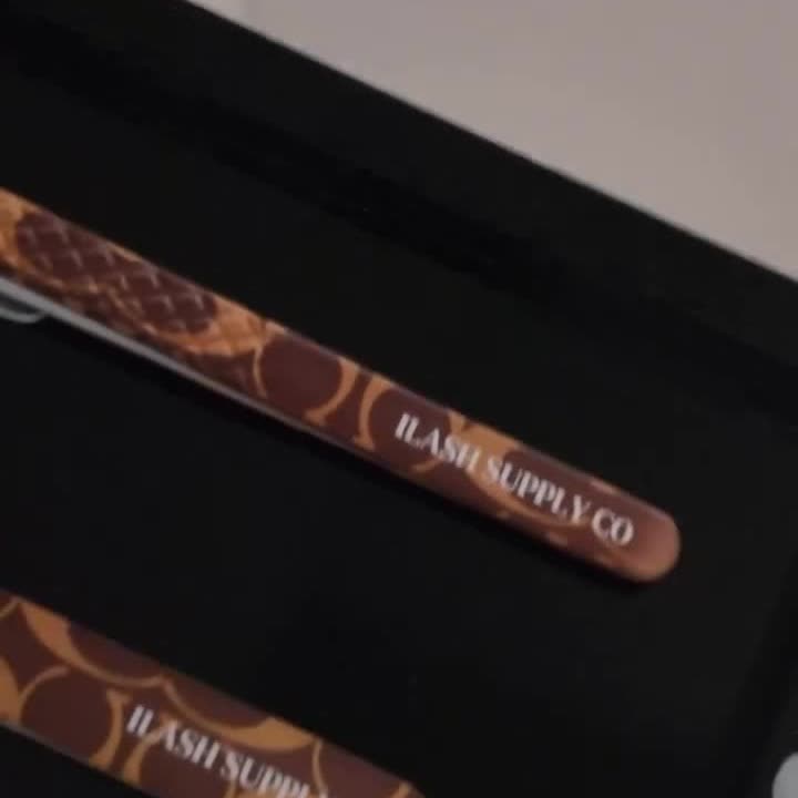 Two iLash Supply Co tweezers in a case